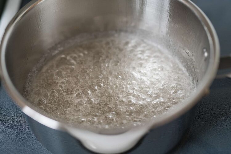 Boiling water in a stainless steel saucepan for cooking or baking process.