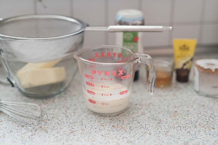 Baked Bree kitchen baking ingredients with measuring cup, whisk, and baking supplies on countertop.