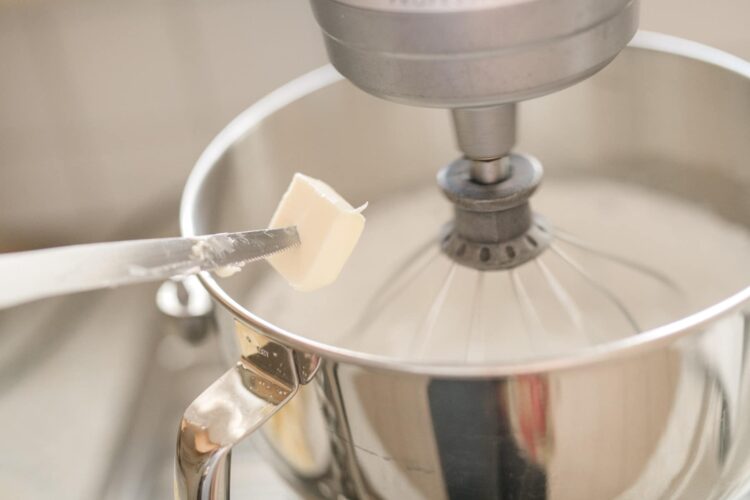 Shredding butter into a stand mixer for baking and pastry recipes.