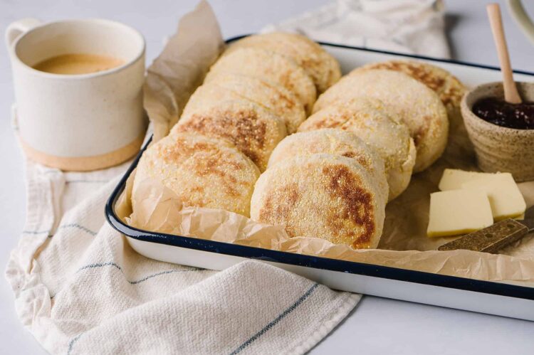 Buttered garlic bread rolls with melted cheese and jam served on a baking tray.