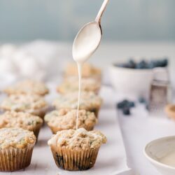 muffins with a spoon drizzling glaze