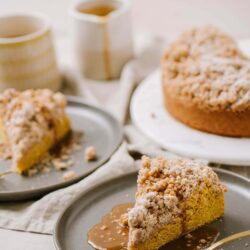 Butter crumb coffee cake with caramel sauce on a gray plate.
