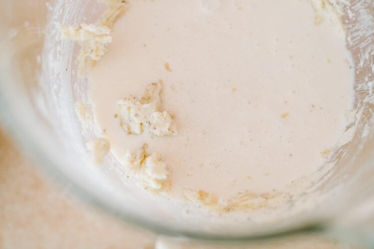 Cream mixture with softened butter in a mixing bowl for baking.