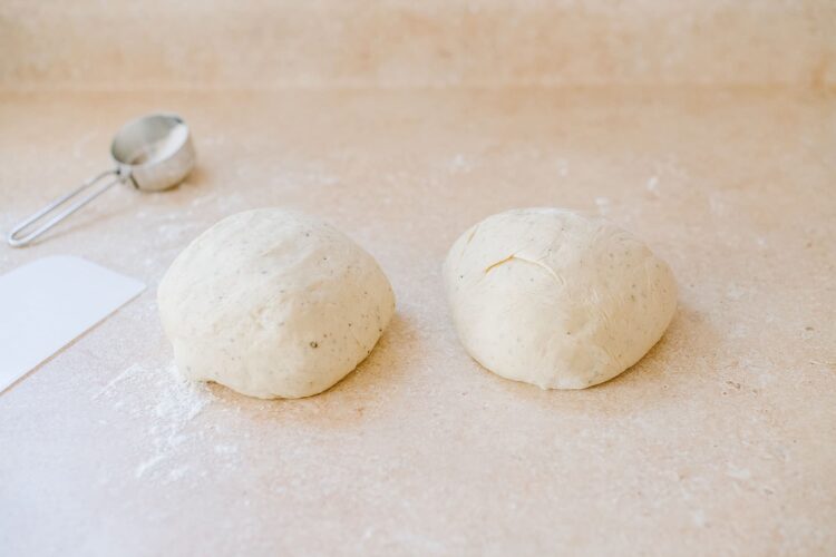 Dough balls on a floured surface for baking bread or pizza.