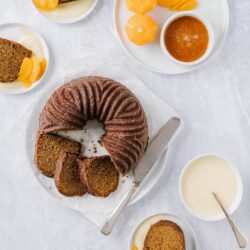 Rich chocolate bundt cake served with creamy sauces and fresh fruit garnishes.