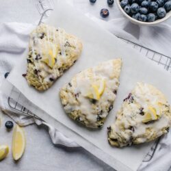 Buttermilk Lemon Blueberry Scones with Glaze, fresh blueberries in a bowl.