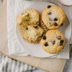 Soft vanilla muffins with chocolate chips on a white plate, perfect for bakery-style breakfast or snack.