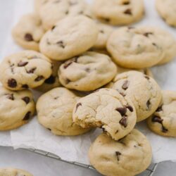 Freshly baked chocolate chip cookies on a cooling rack, homemade cookie recipe, classic cookies with melted chocolate.