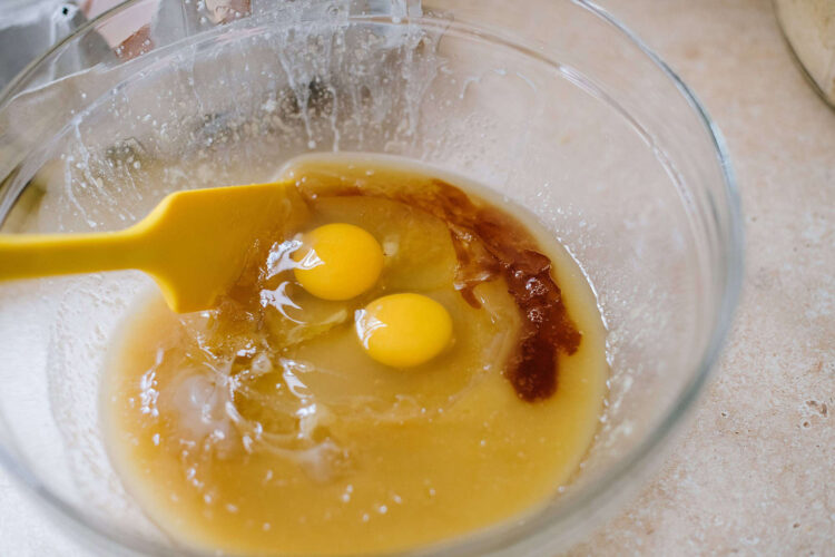 Whisked eggs and ingredients in a glass mixing bowl for baking or cooking recipes.