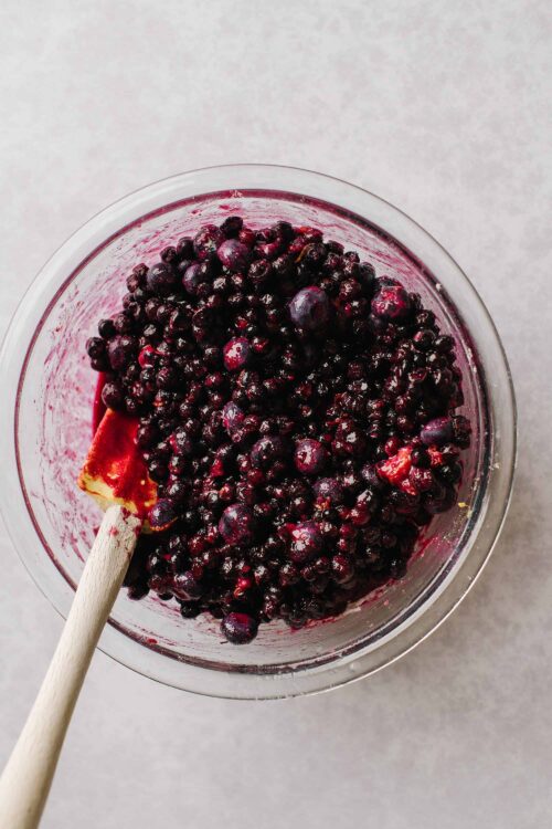 Fresh blackberries in a glass bowl with a spatula, perfect for baking and dessert recipes.