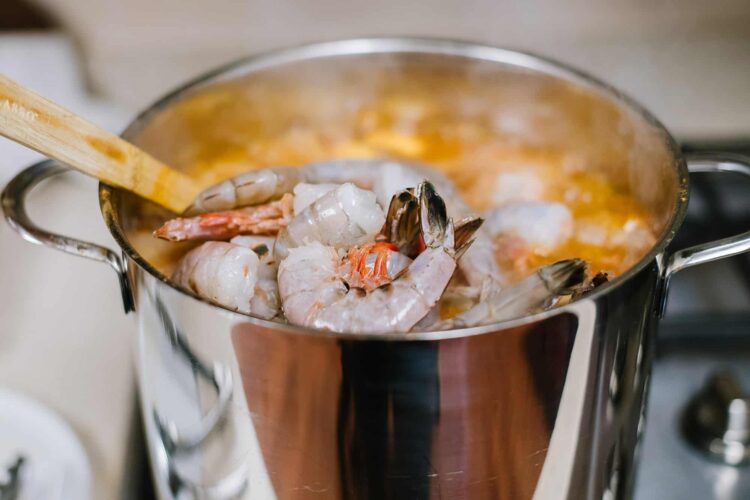 Succulent shrimp and seafood cooking in a stainless steel pot with fragrant broth.