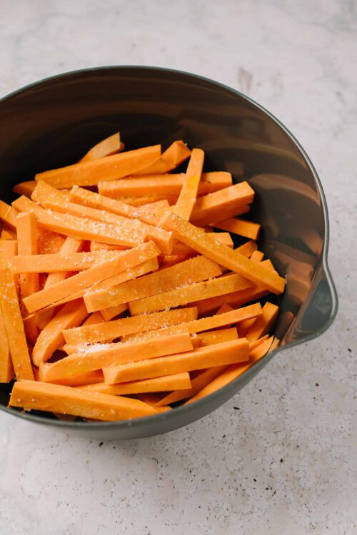 Sliced butternut squash in a gray measuring cup, ready for roasting or cooking.