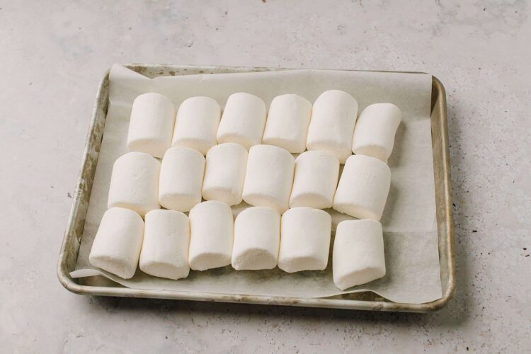 Fluffy marshmallows on baking sheet, ready for roasting or hot chocolate, perfect for cozy desserts.