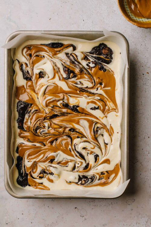 Swirled caramel, chocolate, and vanilla ice cream in a baking dish for homemade ice cream sundae.