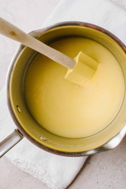 Creamy yellow cheese fondue melted in a pot with a wooden stirrer. Perfect for cheese lovers and gourmet appetizer recipes.