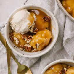 Sweet potato dessert with ice cream and pecans, served in a cozy bowl.