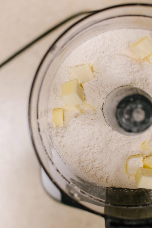 Flour and butter inside a food processor for baking recipes.