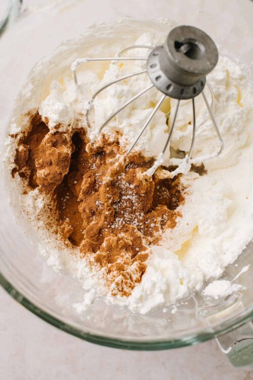 Cream cheese frosting with cocoa powder and sea salt in a mixing bowl.