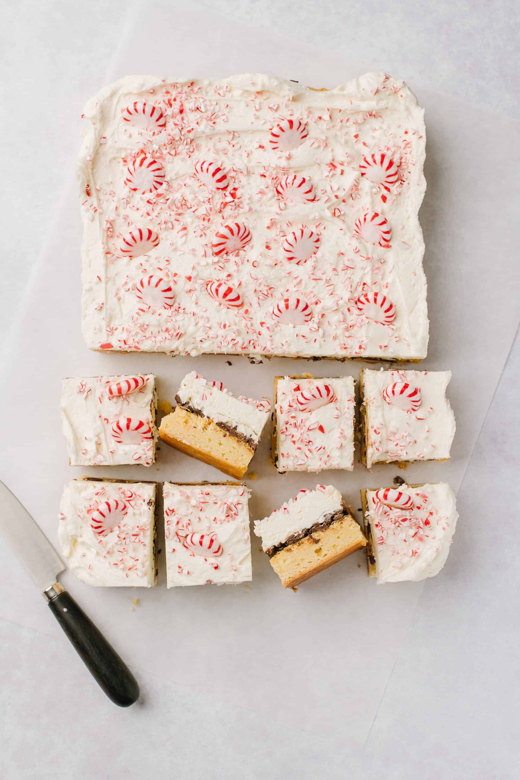 Peppermint bark cheesecake with candy canes and white chocolate frosting, festive holiday dessert.