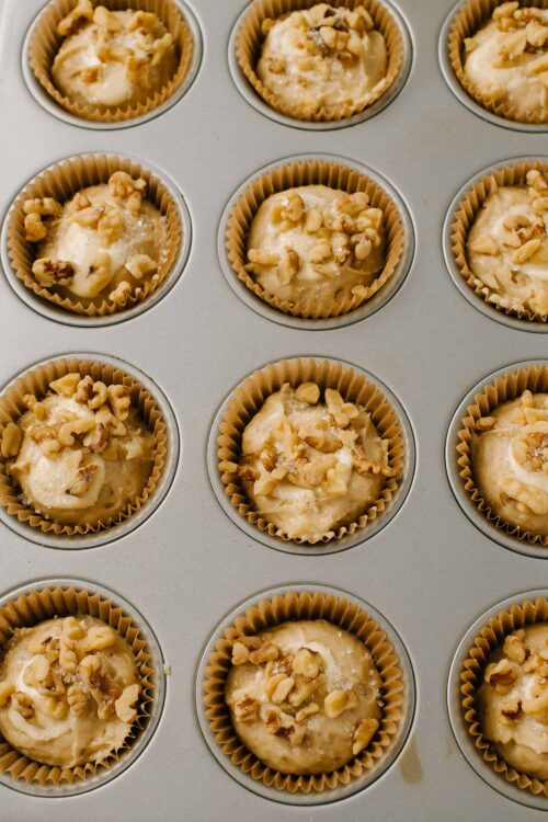 Cream cheese walnut muffins in a muffin tin for baking, freshly prepared and ready to bake.