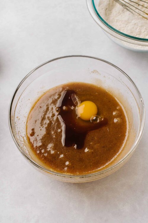 Cream mixture with egg, vanilla, and sugar in glass bowl for baking recipes.