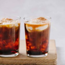 Iced coffee with cream and whipped topping, served in clear glasses.