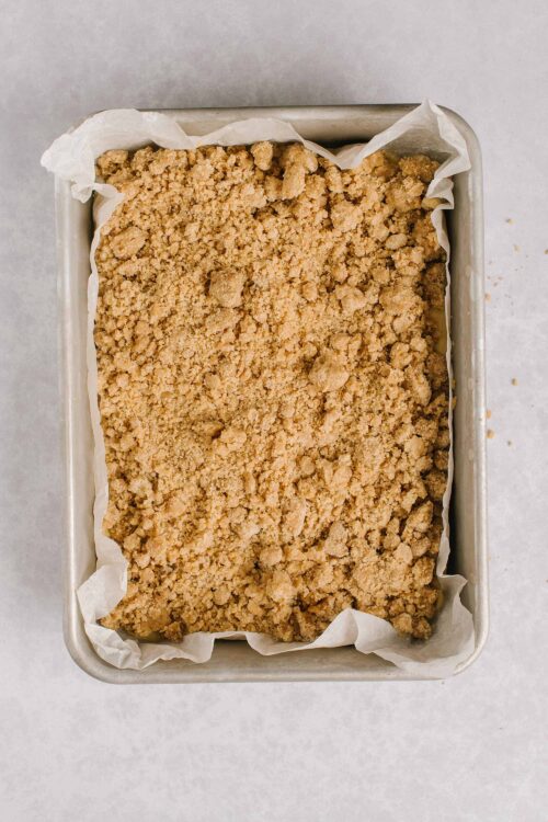 Golden brown crumble topping in a baking dish for apple crisp recipe.