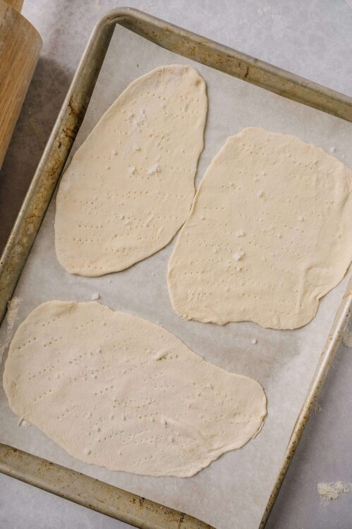 Flaky homemade filo dough stretched on a baking sheet, ready for baking.