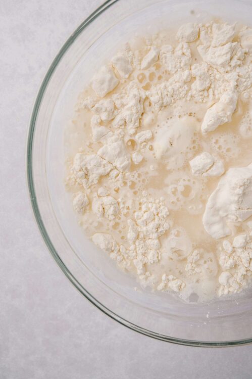 Flour and milk mixture in a glass bowl for baking bread or cake.