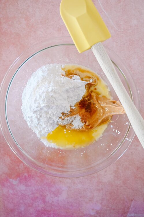 Flour, peanut butter, and wet ingredients in mixing bowl for baking recipes.