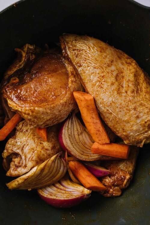 Succulent braised beef and vegetables cooking in a skillet for a hearty meal.