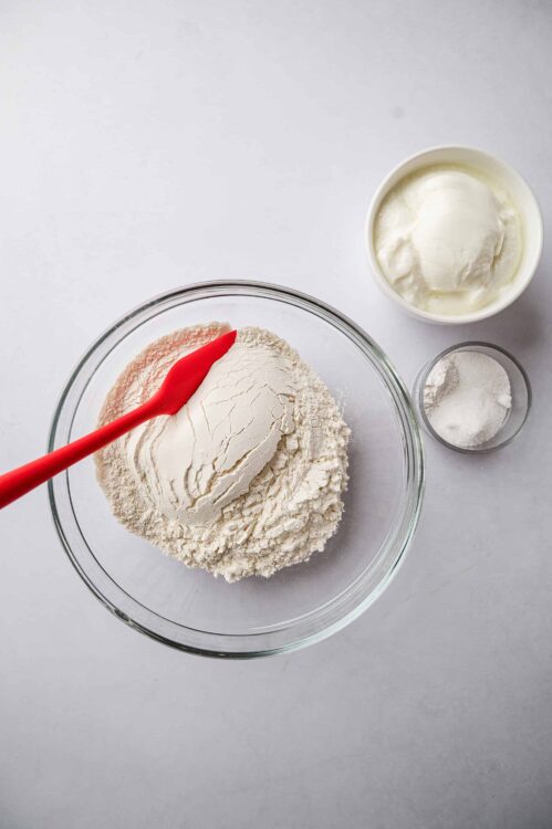 Flour, salt, and sour cream in glass bowls for baking.