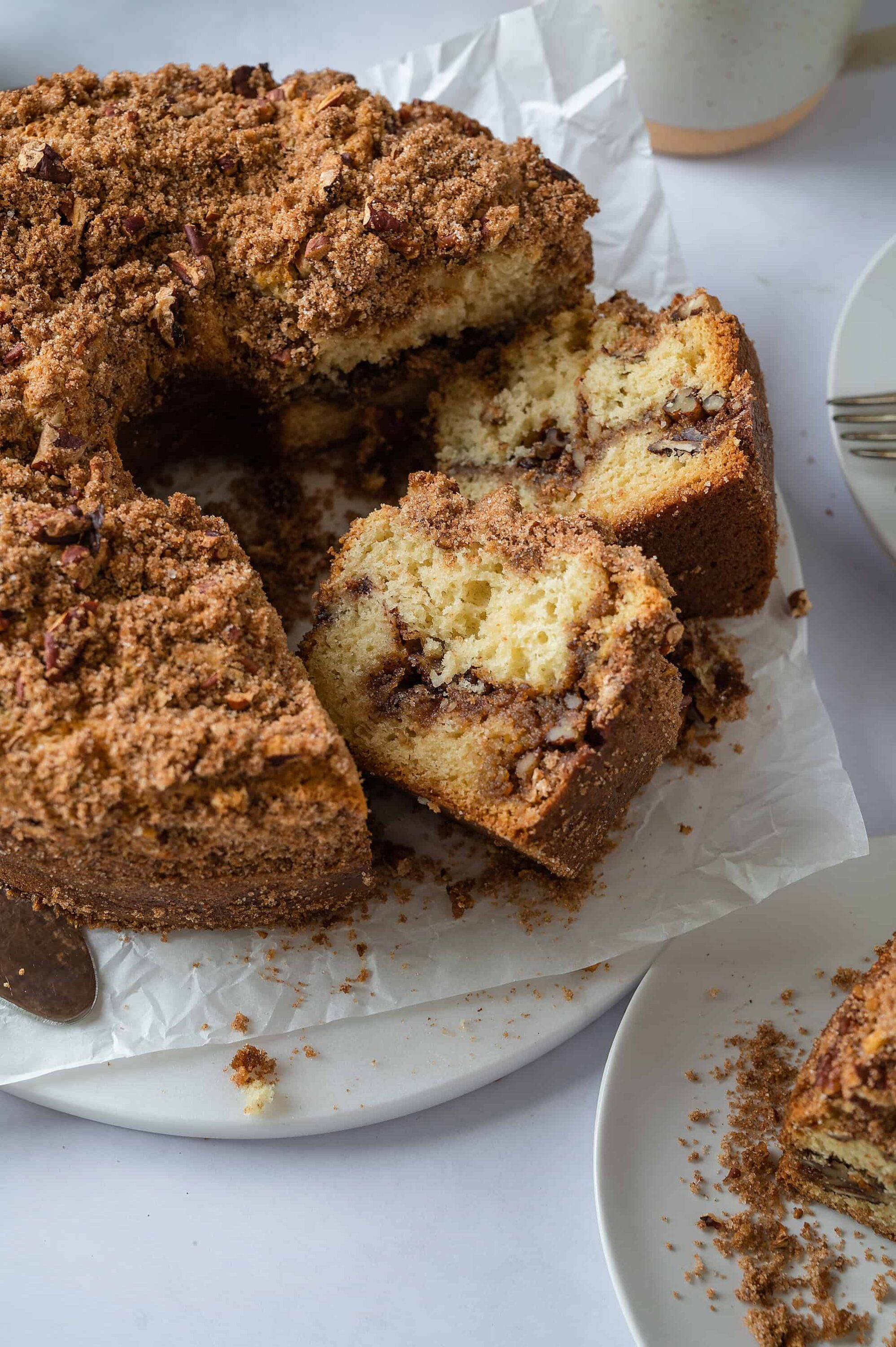Rich chocolate chip coffee cake with crumb topping, served on a white platter.