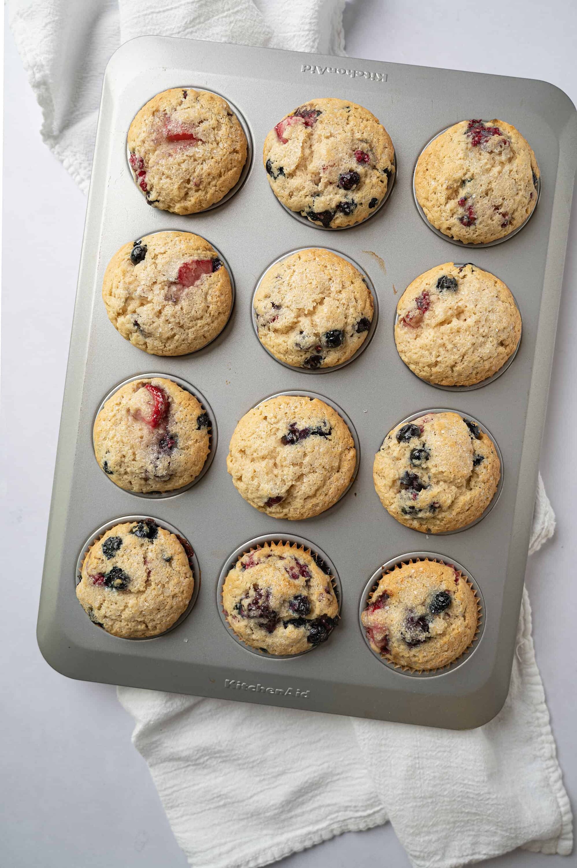 Freshly baked blueberry muffins in a baking pan.