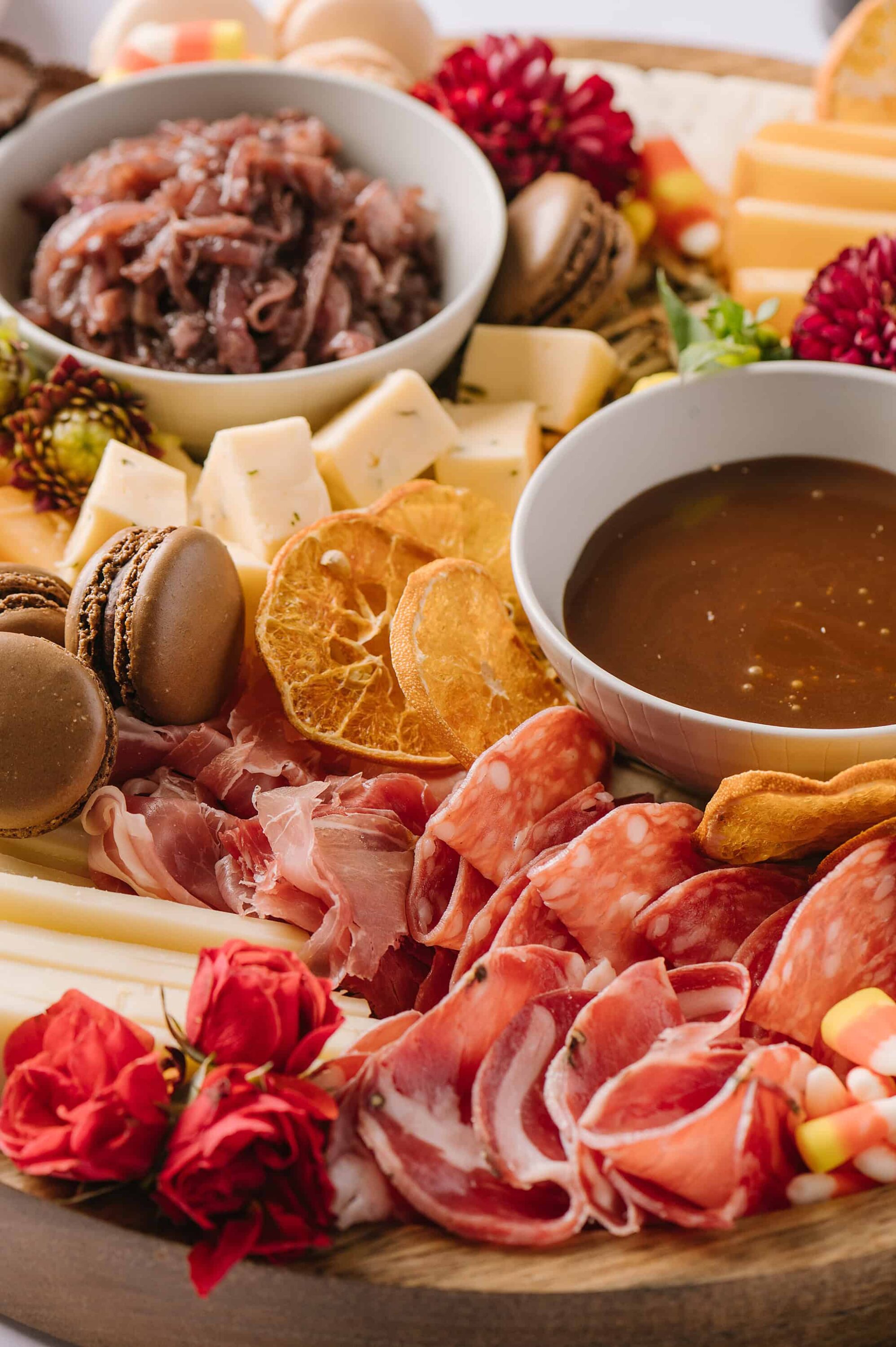 Slices of cured meats, cheeses, dried fruits, and crackers on a charcuterie board, perfect for cheese and charcuterie platter.