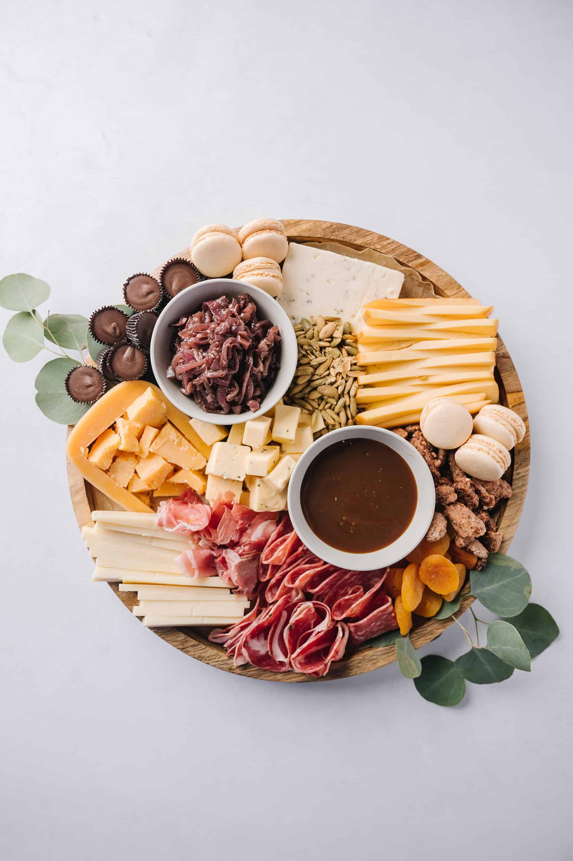 Assorted charcuterie board with cheeses, meats, crackers, dried fruits, and spreads for entertaining.