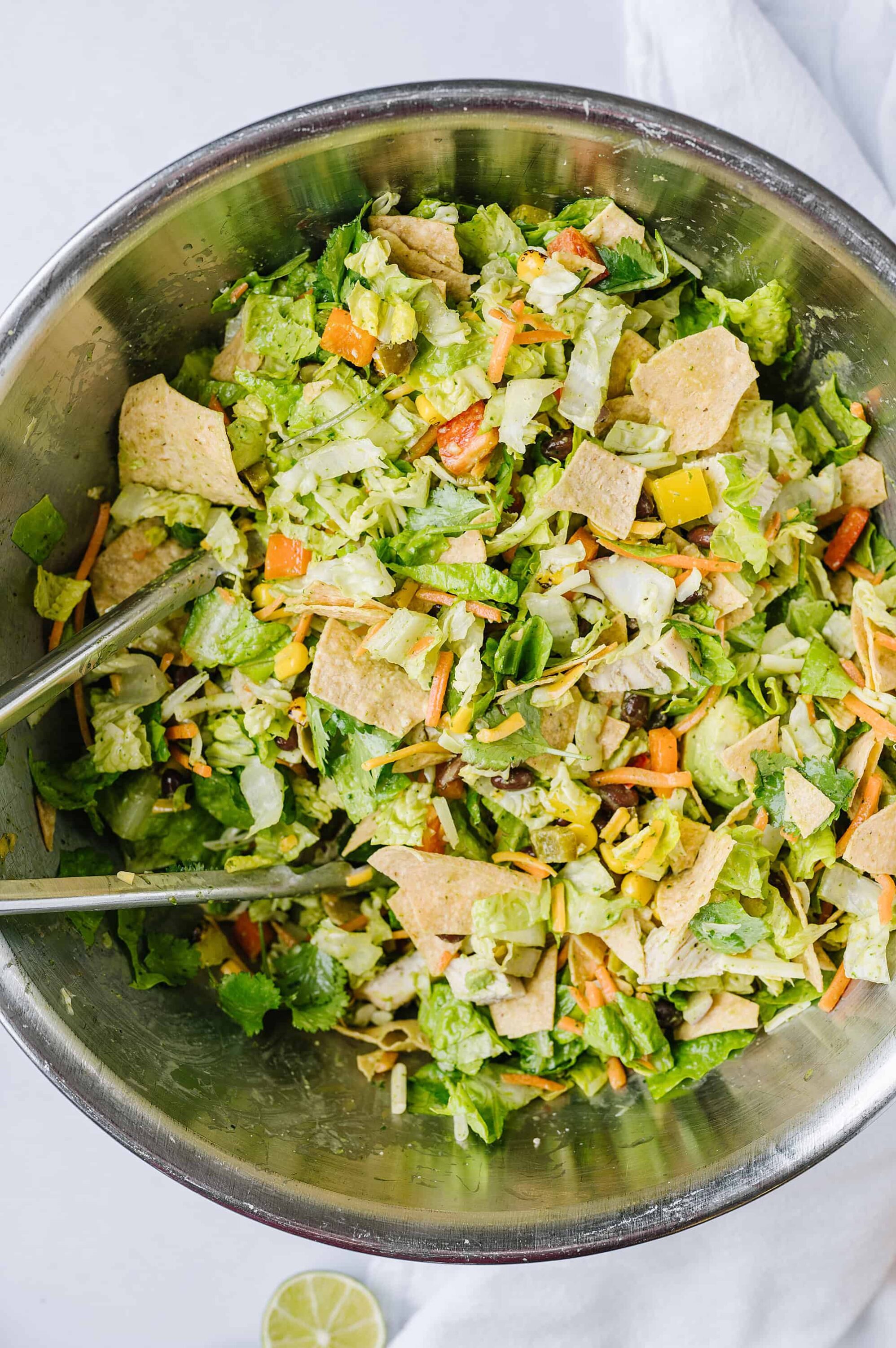 Fresh vegetable taco salad with tortilla chips in a stainless steel bowl, healthy and colorful summer dish, Baked Bree recipes.