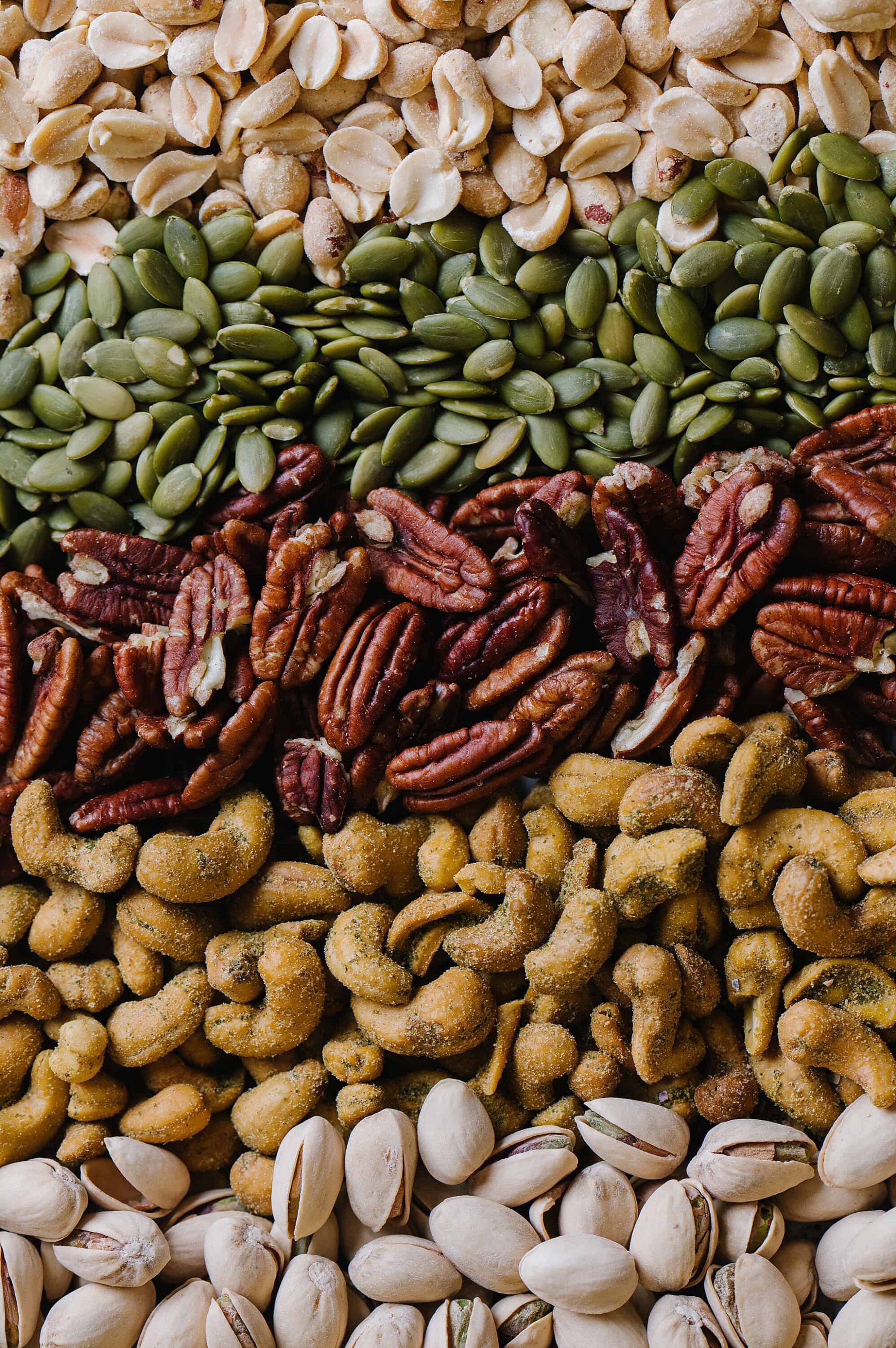 Unsalted mixed nuts including cashews, pistachios, pecans, and almonds close-up.