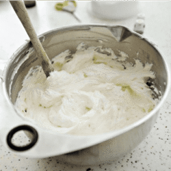 Cream cheese being mixed in a stainless steel bowl for a baking recipe.