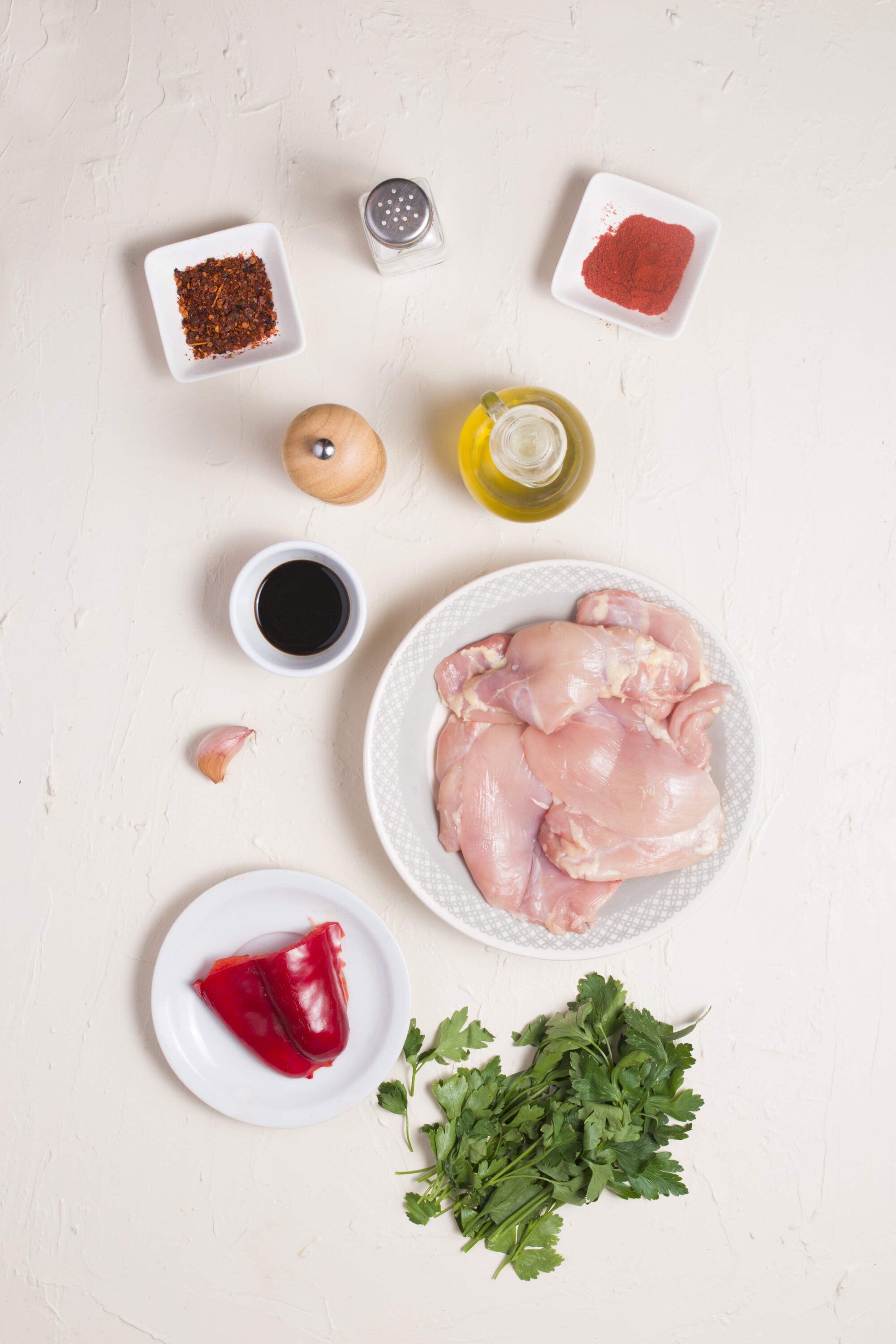 Fresh raw chicken breasts with garlic, red pepper, and herbs for cooking recipe.