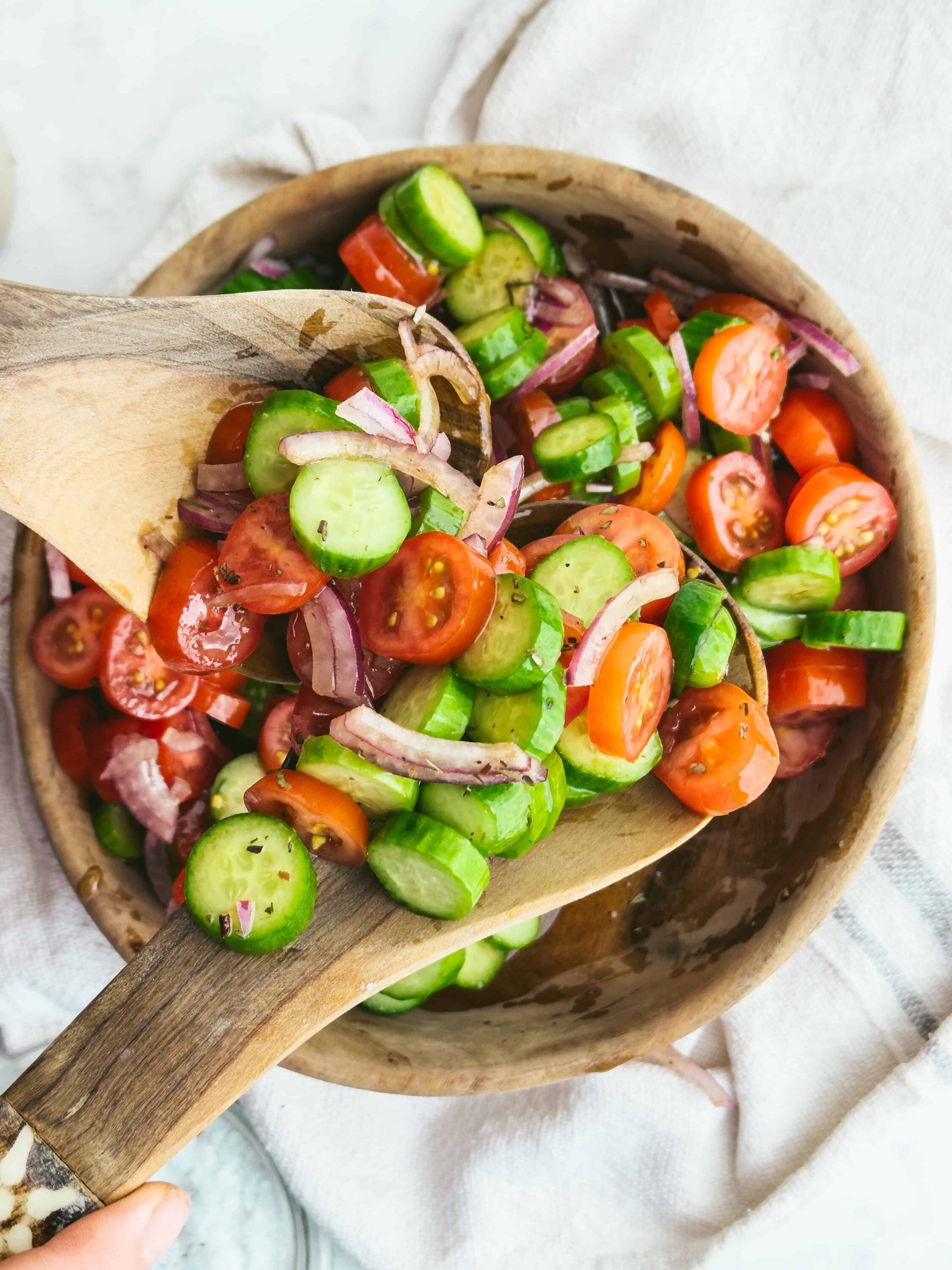 Fresh homemade garden cucumber tomato onion salad in wooden bowl, healthy and vibrant summer appetizer.