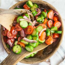 Fresh homemade garden cucumber tomato onion salad in wooden bowl, healthy and vibrant summer appetizer.
