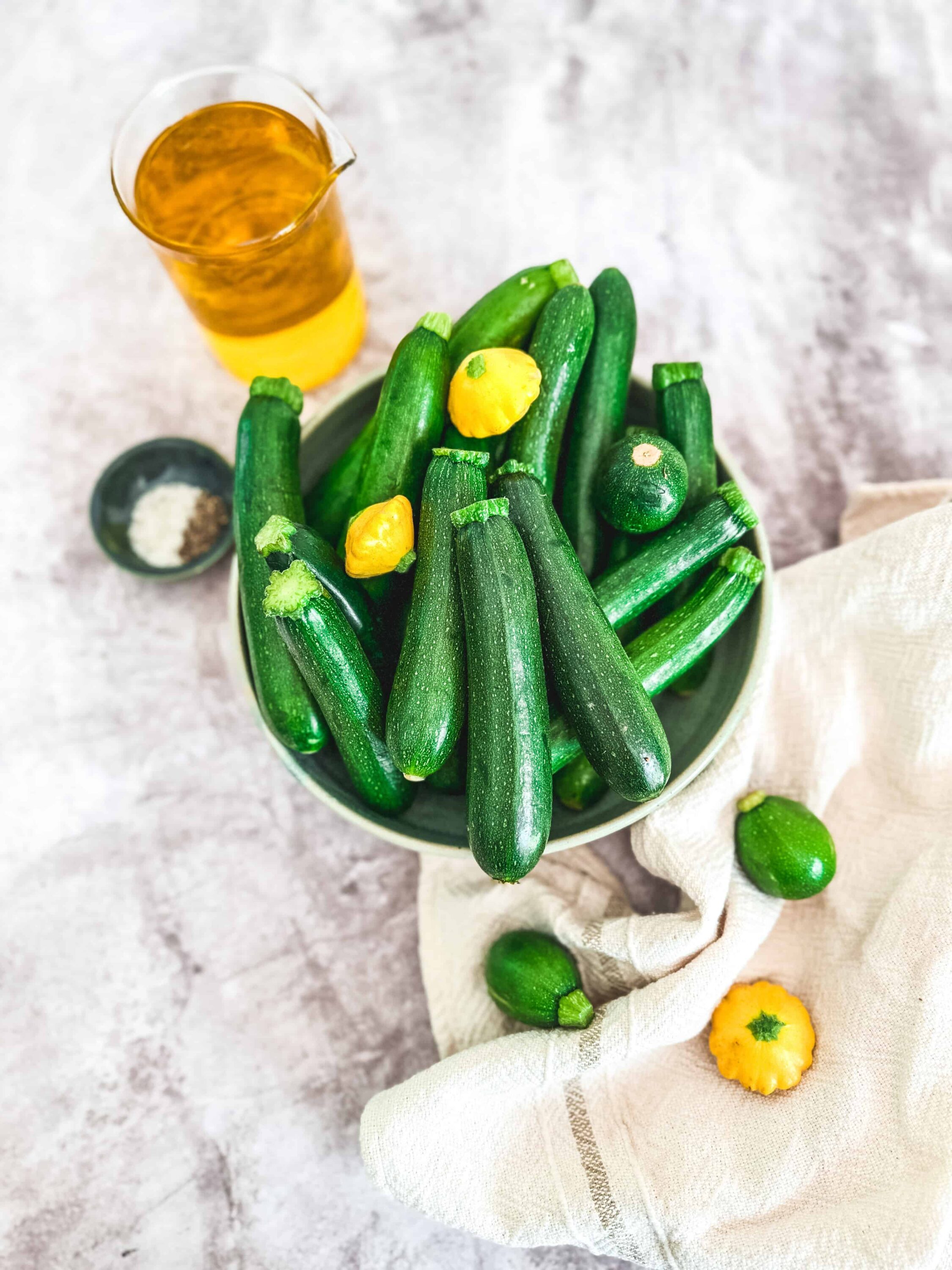 Crisp zucchinis with yellow pattypans on a white bowl, fresh from the garden, healthy summer vegetable snack.