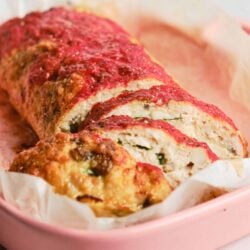 Fresh homemade meatloaf with tomato glaze in a pink baking dish, ready to serve.