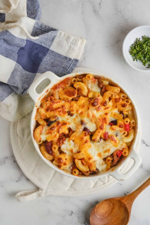 Creamy baked pasta casserole with cheese, ground beef, and vegetables in a white baking dish.