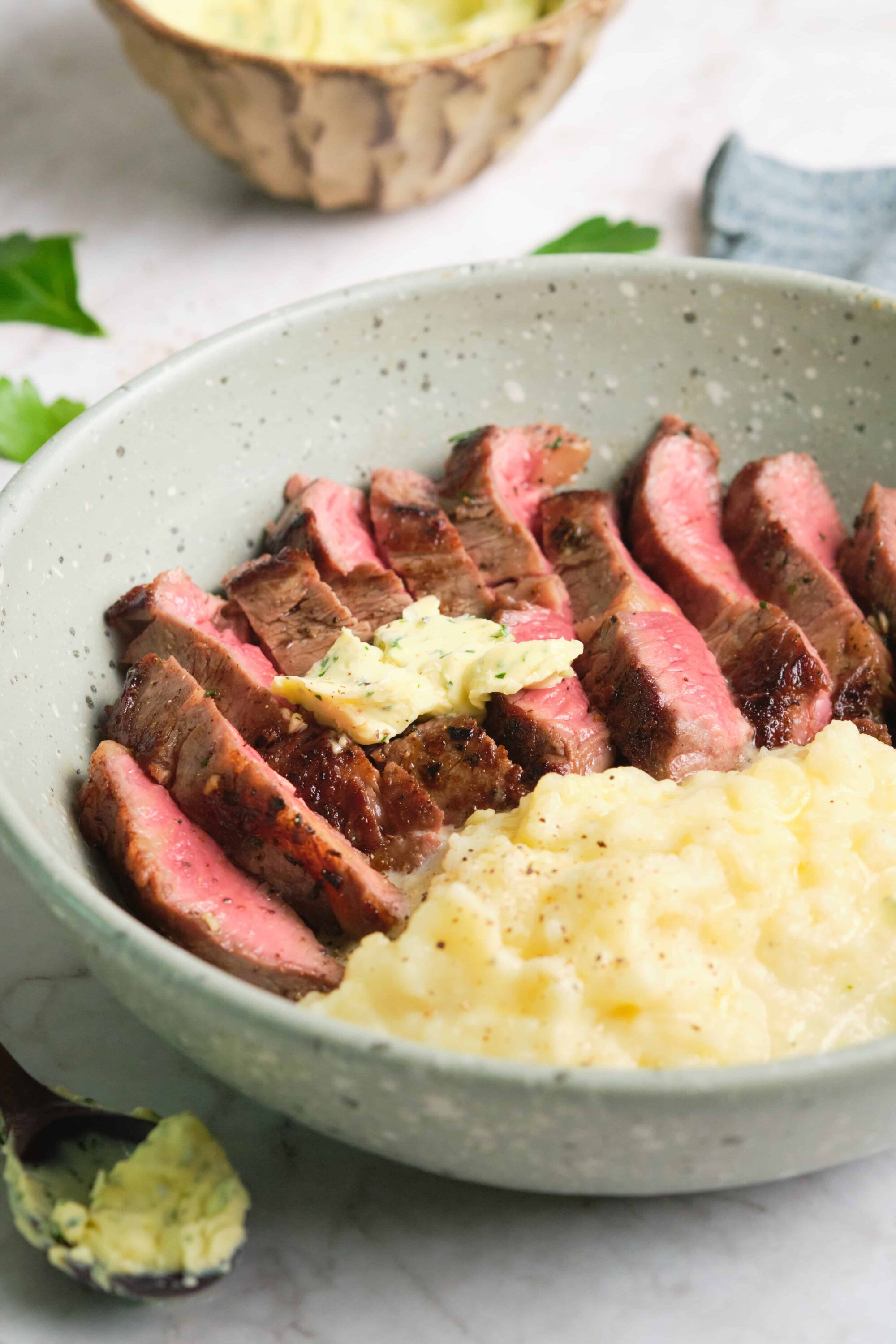 Juicy steak with mashed potatoes in a rustic bowl, perfect comfort food.