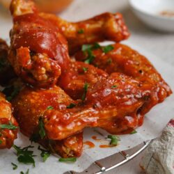 Crispy buffalo chicken wings with spicy sauce and fresh herbs.