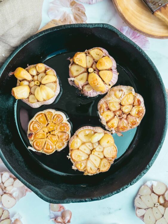 Garlic roasted bulb garlic on cast iron skillet for baking or cooking.