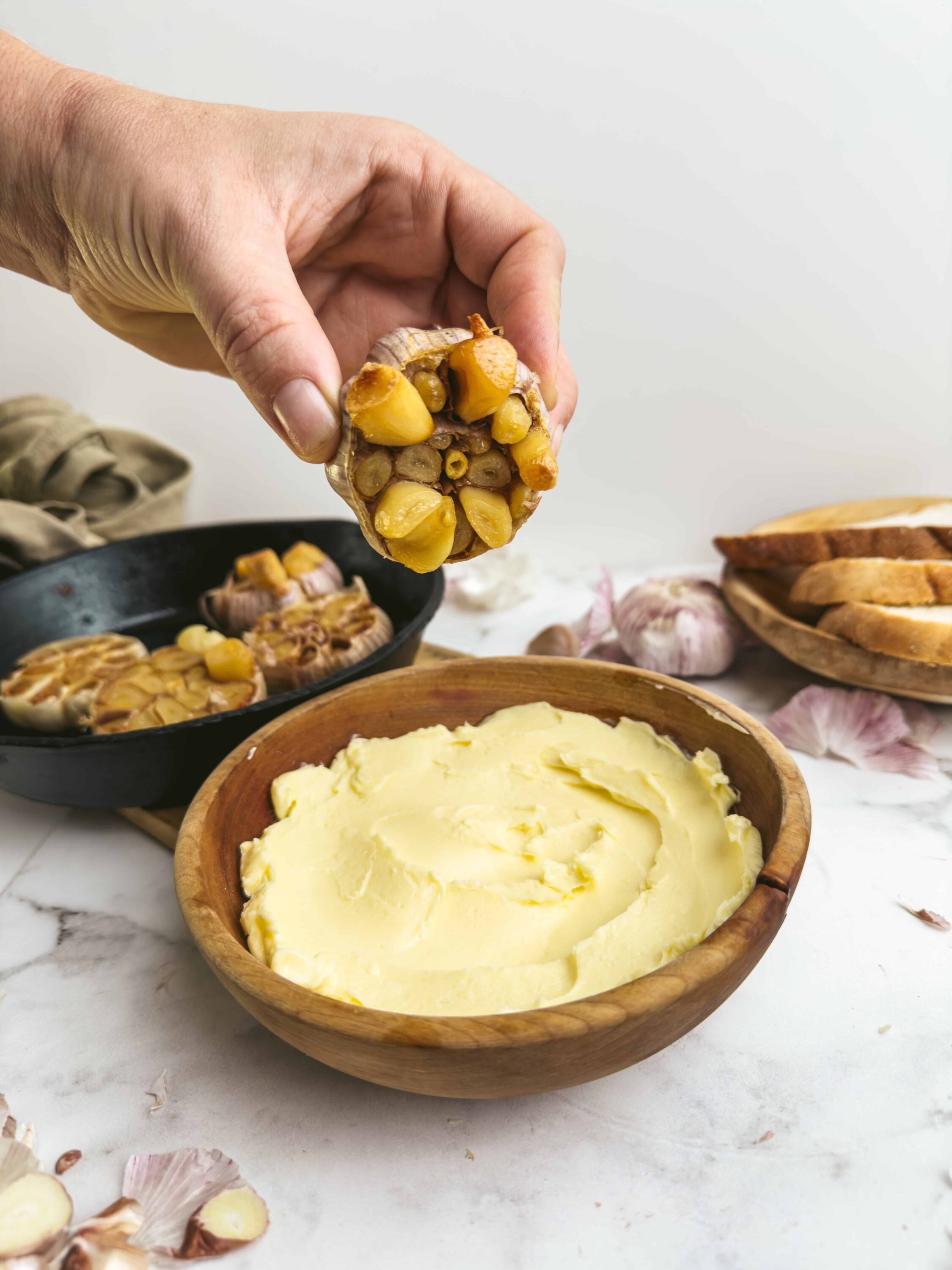 Sweet garlic roasted chicken in a rustic kitchen setting with mashed potatoes and garlic bulbs.