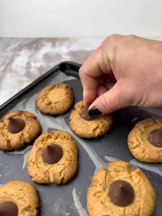 Rich chocolate thumbprint cookies on baking tray.